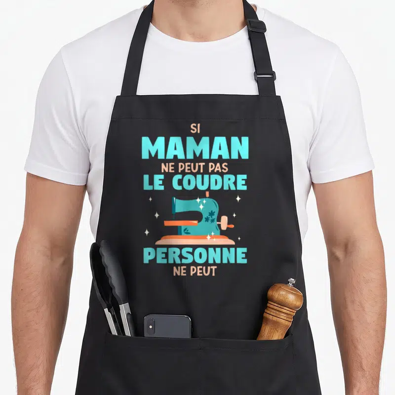 Tablier de cuisine noir avec une machine à coudre turquoise et le texte Si maman ne peut pas le coudre personne ne peut.