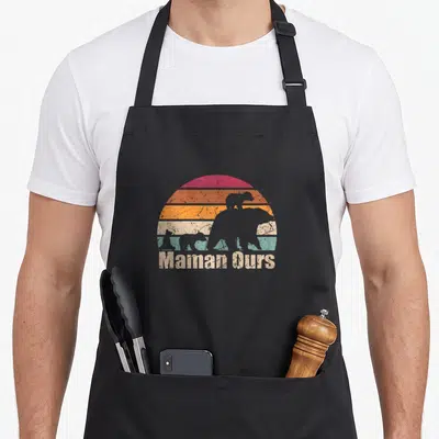 Tablier de cuisine noir avec silhouette de maman ours et trois petits devant un soleil rayé retro.