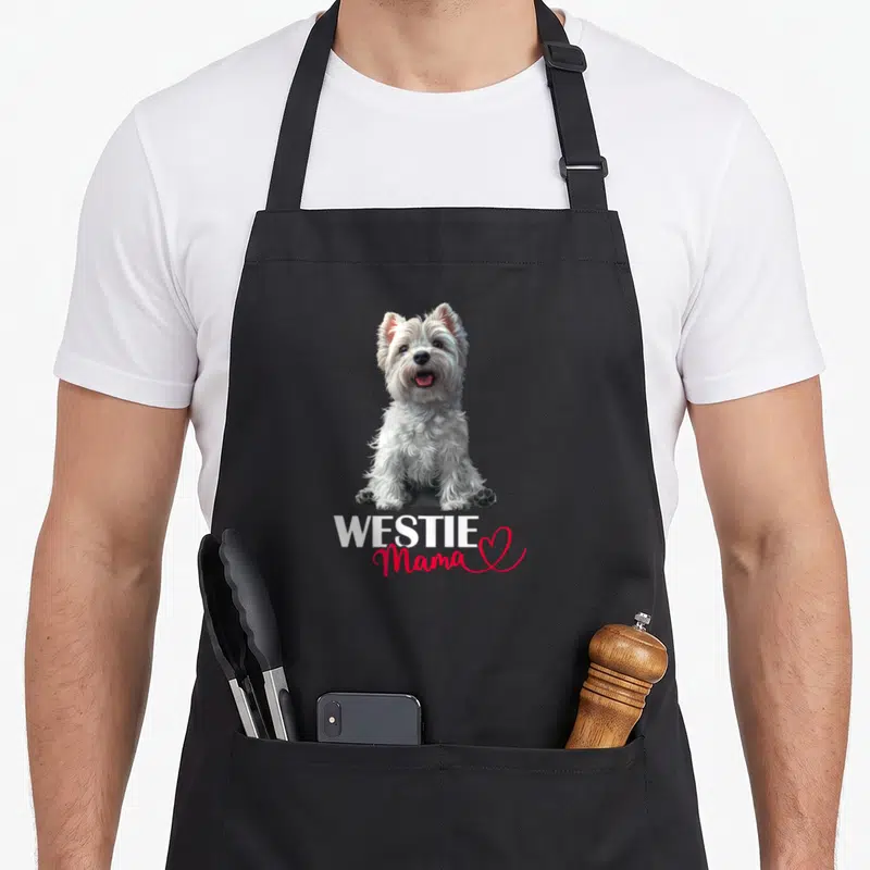 Tablier de cuisine noir avec illustration d'un chien blanc assis et le texte WESTIE Mama en rose