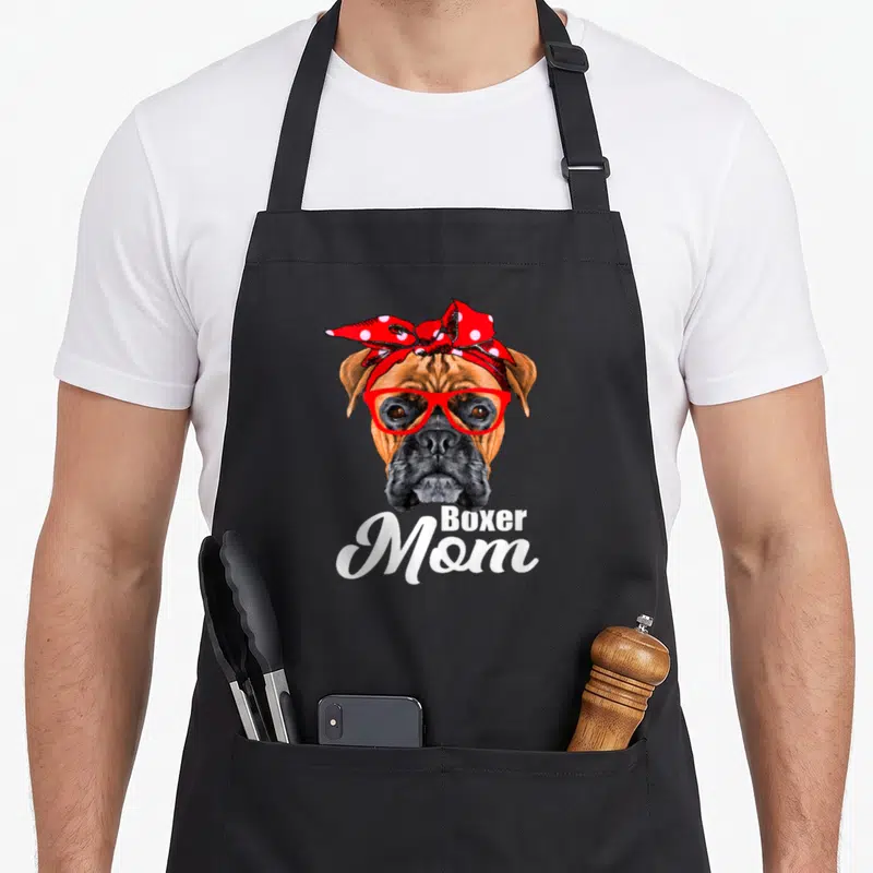 Tablier de cuisine noir avec illustration d'un boxer portant des lunettes rouges et un foulard à pois rouges sur la tête.
