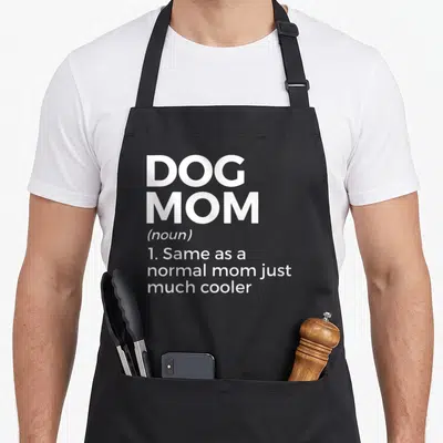 Tablier de cuisine noir avec l'inscription blanche Dog Mom et sa définition humoristique en anglais.