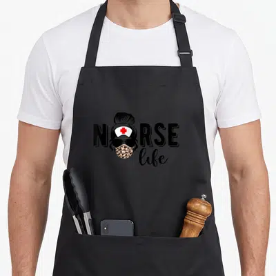 Tablier de cuisine noir avec illustration d'une infirmière coiffée d'un bun, portant des lunettes noires et un masque à motif léopard.