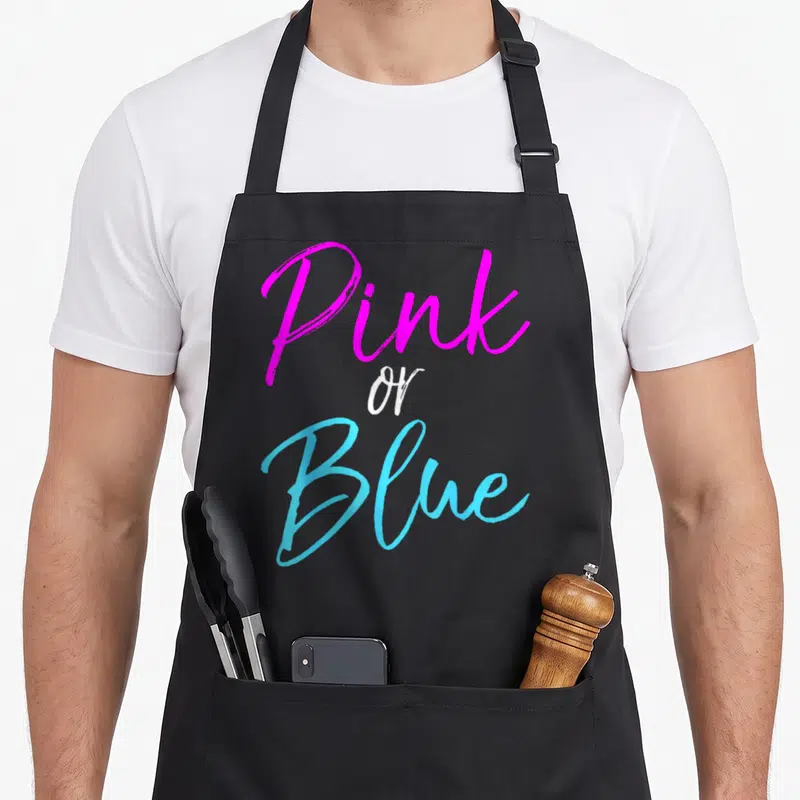 Tablier de cuisine noir avec l'inscription Pink or Blue en rose et bleu vif.