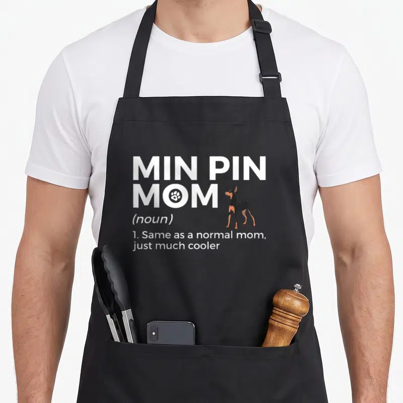 Tablier de cuisine noir avec inscription Min Pin Mom et illustration d'un petit chien noir et feu.