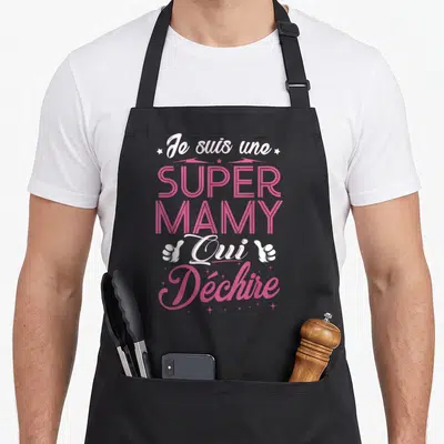 Tablier de cuisine noir avec inscription rose Je suis une SUPER MAMY Qui Déchire et deux pouces levés blancs.