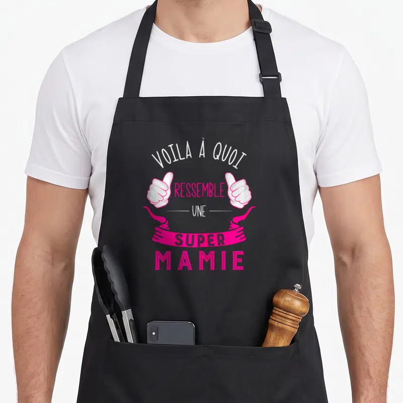 Tablier de cuisine noir avec inscription rose et blanche Voila à quoi ressemble une super Mamie et deux pouces levés.