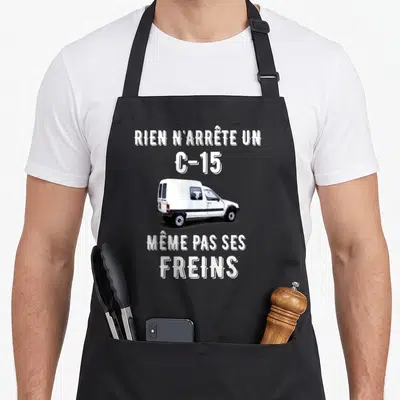 Tablier de cuisine noir avec illustration d'un C-15 blanc et texte blanc sur fond gris uni