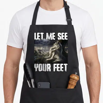Tablier de cuisine noir avec illustration d'un loup assis et le texte Let Me See Your Feet en lettres blanches capitales.