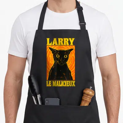 Tablier de cuisine noir avec illustration d'un chat noir Larry le malicieux sur fond orange et texte jaune en haut et en bas.