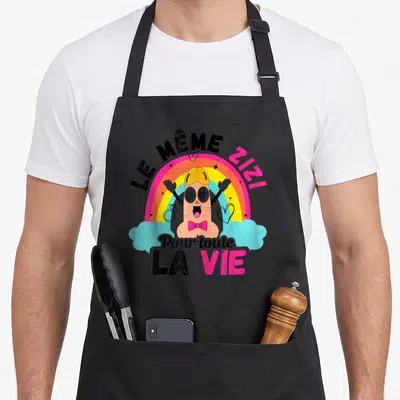 Tablier de cuisine noir avec illustration colorée d'un personnage souriant sous un arc-en-ciel et des nuages bleus.