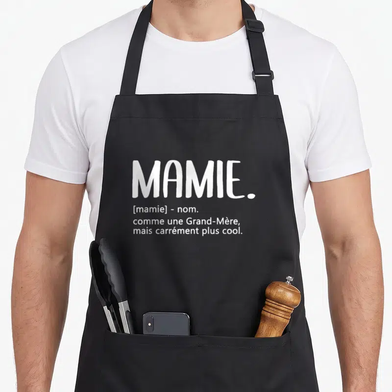Tablier de cuisine noir avec le texte blanc Mamie comme une Grand-Mère mais carrément plus cool imprimé au centre.
