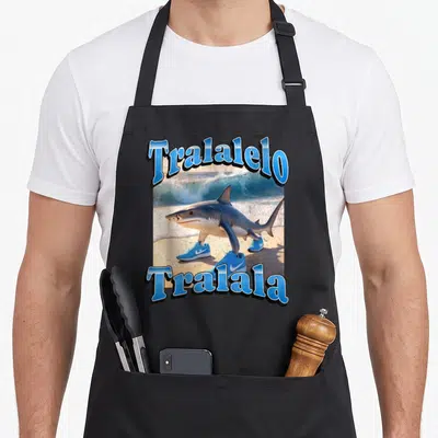 Tablier de cuisine noir avec un requin portant des baskets bleues et du texte bleu Tralalelo Tralala.