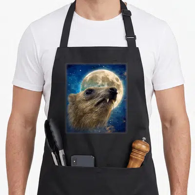 Tablier de cuisine noir avec illustration d'un Rock Hyrax face à une pleine lune sur fond d'espace bleu.
