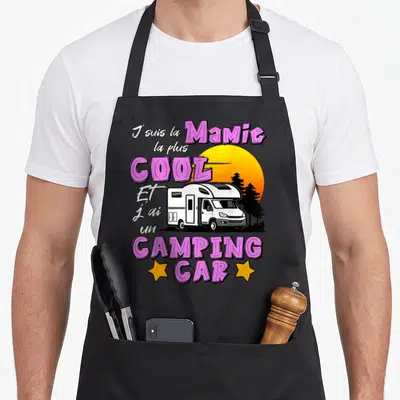 Tablier de cuisine noir avec illustration de camping car, texte Mamie la plus cool et soleil orange.