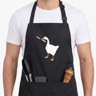 Tablier de cuisine noir avec une illustration d'une oie blanche tenant un couteau et le texte Peace Was Never An Option.