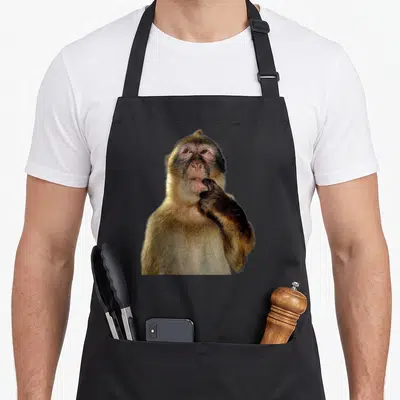 Tablier de cuisine noir avec photographie d'un singe posant la main sur sa bouche en signe de pensée.