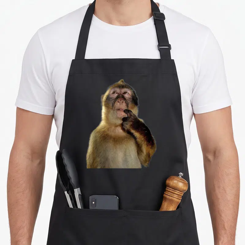 Tablier de cuisine noir avec photographie d'un singe posant la main sur sa bouche en signe de pensée.