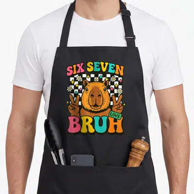 Tablier de cuisine noir avec un capybara faisant deux signes de la paix entouré des mots Six Seven Bruh et Love.