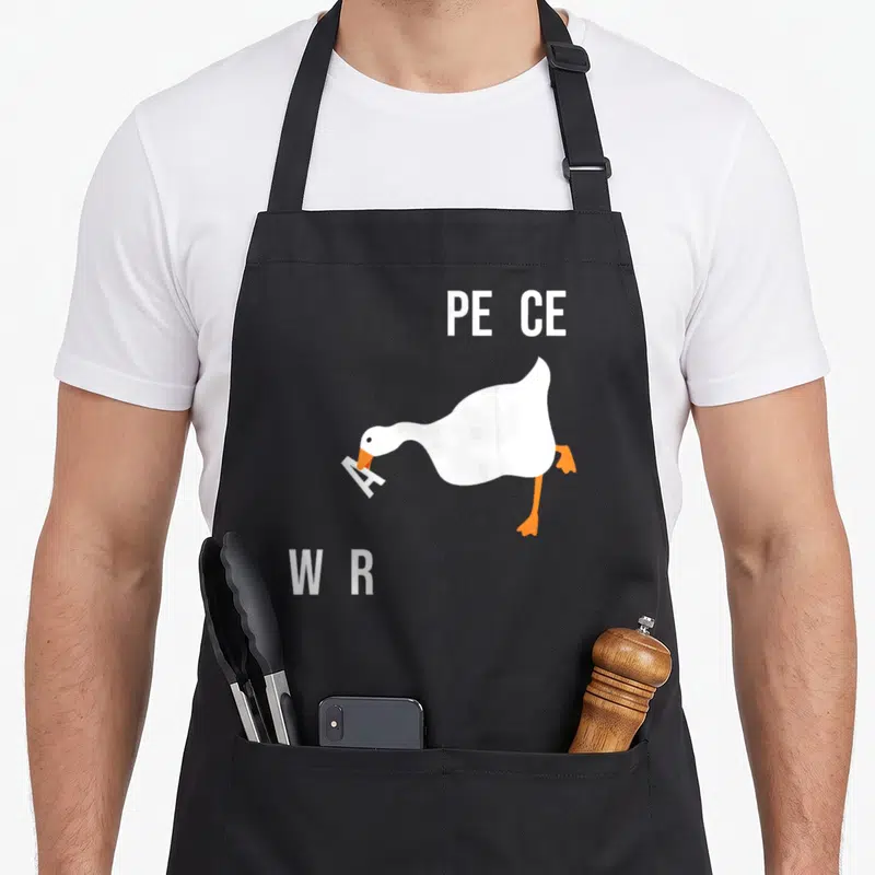 Tablier de cuisine noir avec oiseau blanc tenant une lettre A dans son bec orange, entouré des mots PE CE et WR en blanc.