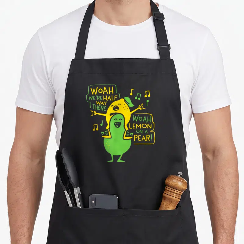 Tablier de cuisine noir avec illustration d'un citron jaune sur une poire verte et notes de musique colorées.