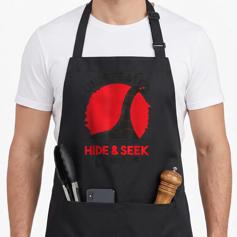 Tablier de cuisine noir avec illustration d'un monstre du Loch Ness rouge et noir portant des lunettes de soleil.