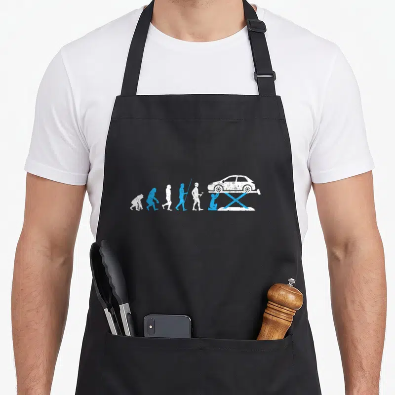 Tablier de cuisine noir avec illustration évolution humaine terminant par un mécanicien sous véhicule sur crosse bleue