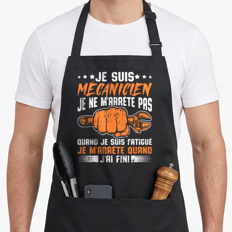 Tablier de cuisine noir avec poing orange tenant une clé et texte blanc et orange.