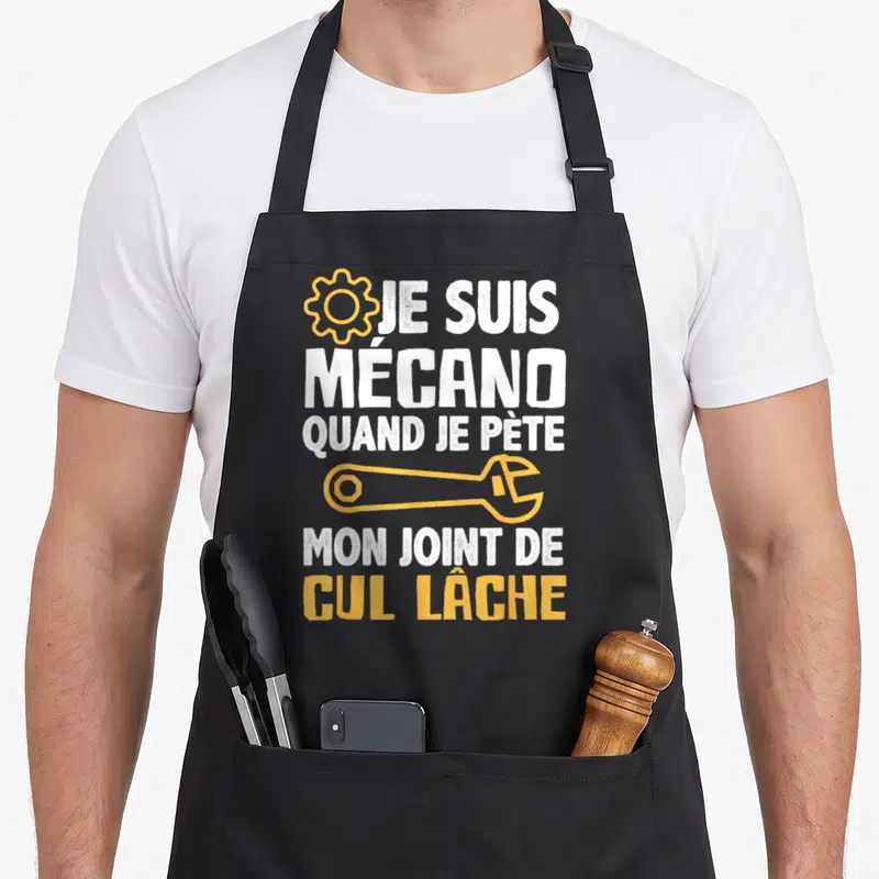 Tablier de cuisine noir avec inscription blanche et jaune Je suis mécano quand je pète mon joint de cul lâche sur fond uni.