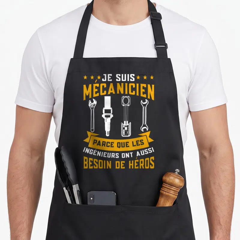 Tablier de cuisine noir avec inscription Je suis mécanicien et illustration d'outils automobiles en blanc et orange.