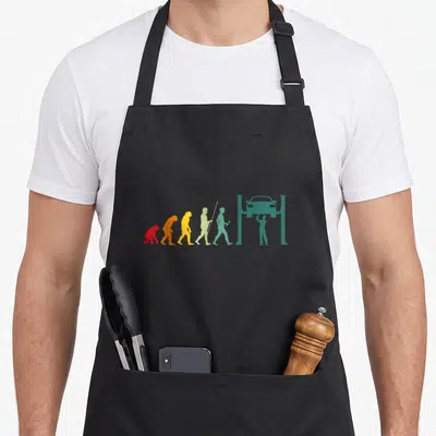 Tablier de cuisine noir avec silhouette évolutive menant à un mécanicien sous voiture sur pont.