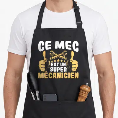 Tablier de cuisine noir avec inscription Ce mec est un super mécanicien, deux mains faisant des pouces levés et deux clés croisées en jaune.