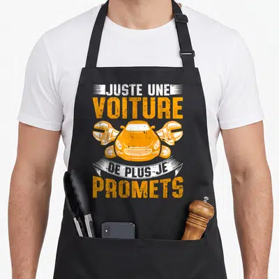 Tablier de cuisine noir avec une illustration orange d'une voiture et deux clés croisées sur un fond uni.