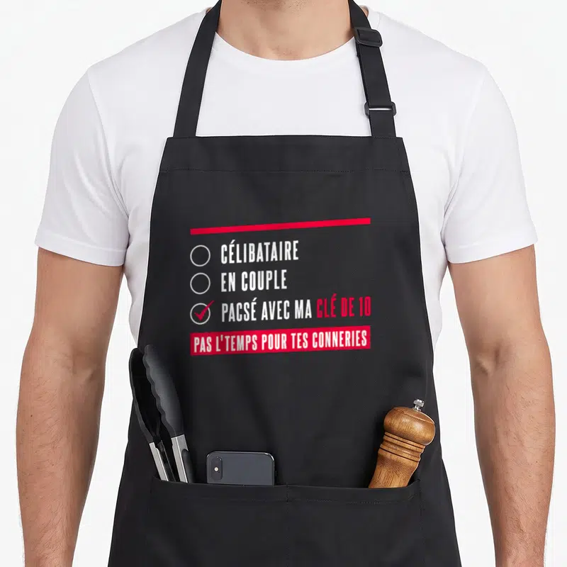 Tablier de cuisine noir avec une illustration rouge et blanche citant un mec pacsé avec sa clé de 10.