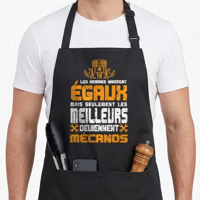 Tablier de cuisine noir avec inscription Les hommes naissent égaux mais seulement les meilleurs deviennent mécanos sur fond gris uni