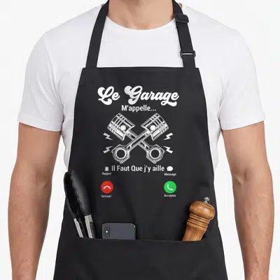 Tablier de cuisine noir avec illustration d'appel entrant et pistons croisés blancs sur fond sombre.