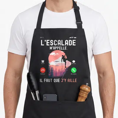Tablier de cuisine noir avec illustration d'un téléphone affichant un grimpeur et le texte L'escalade m'appelle.