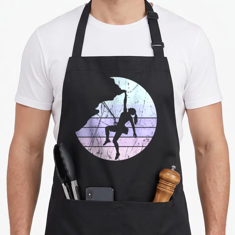 Tablier de cuisine noir avec silhouette de grimpeuse femme dans un cercle aux couleurs pastel rétro.