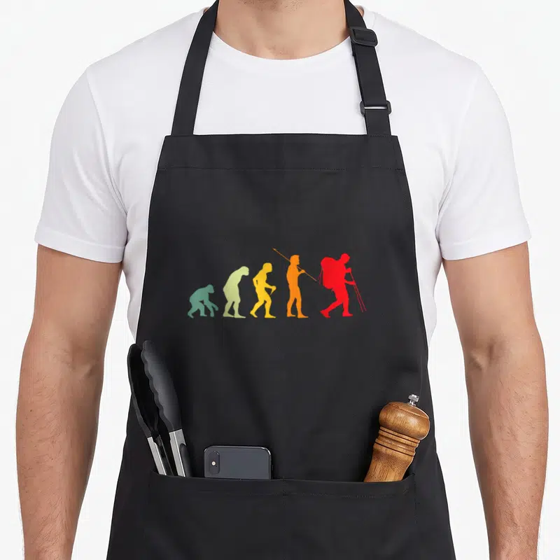 Tablier de cuisine noir avec silhouette évolutive colorée d'un randonneur final rouge à bâtons et sac dos.