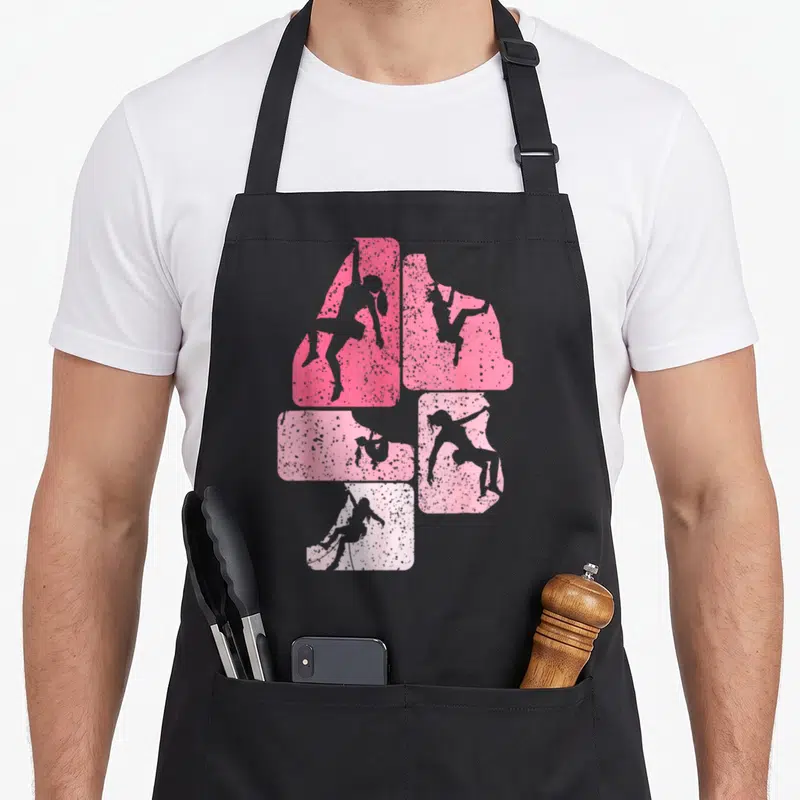 Tablier de cuisine noir avec des silhouettes de femmes grimpant sur des blocs roses texturés.