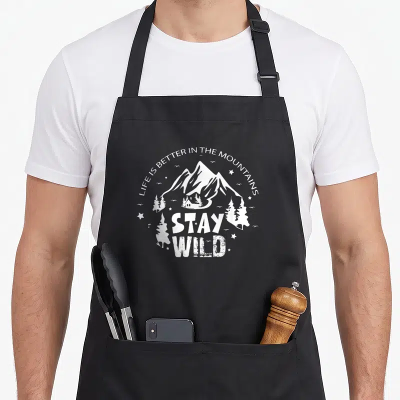 Tablier de cuisine noir avec illustration blanchemontagne chalet et texte Life is Better in the Mountains Stay Wild