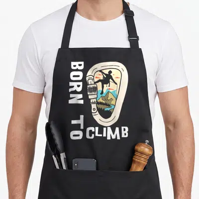 Tablier de cuisine noir avec illustration mousqueton vintage, silhouette grimpeur et texte Born To Climb vertical.