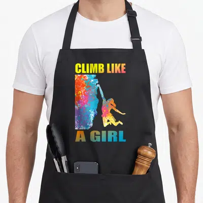 Tablier de cuisine noir avec une silhouette de grimpeuse colorée et le texte CLIMB LIKE A GIRL en dégradé.