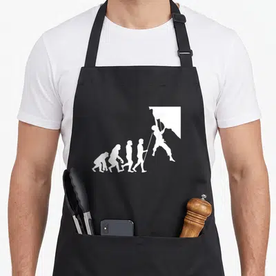 Tablier de cuisine noir avec une illustration blanche représentant l'évolution humaine se terminant par un silhouetté d'escaladeur accroché à la paroi.