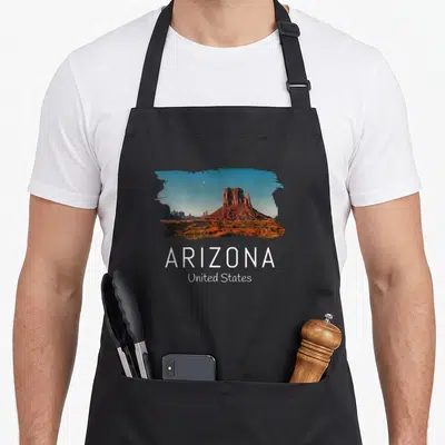 Tablier de cuisine noir avec illustration d'un paysage rocheux rouge et le texte ARIZONA United States en blanc.