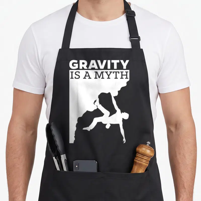 Tablier de cuisine noir avec une silhouette blanche d'escaladeur et le texte en anglais.
