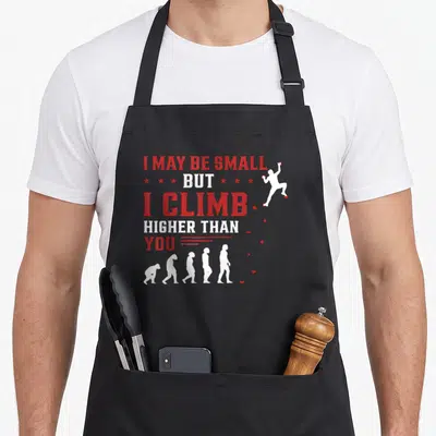 Tablier de cuisine noir avec silhouette grimpeur et texte I may be small but I climb higher than you en rouge et blanc.