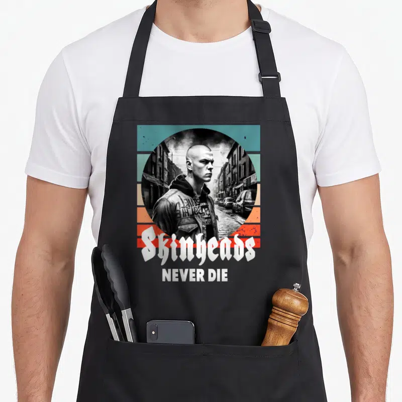 Tablier de cuisine noir avec illustration d'un homme en veste de cuir et texte Skinheads Never Die.