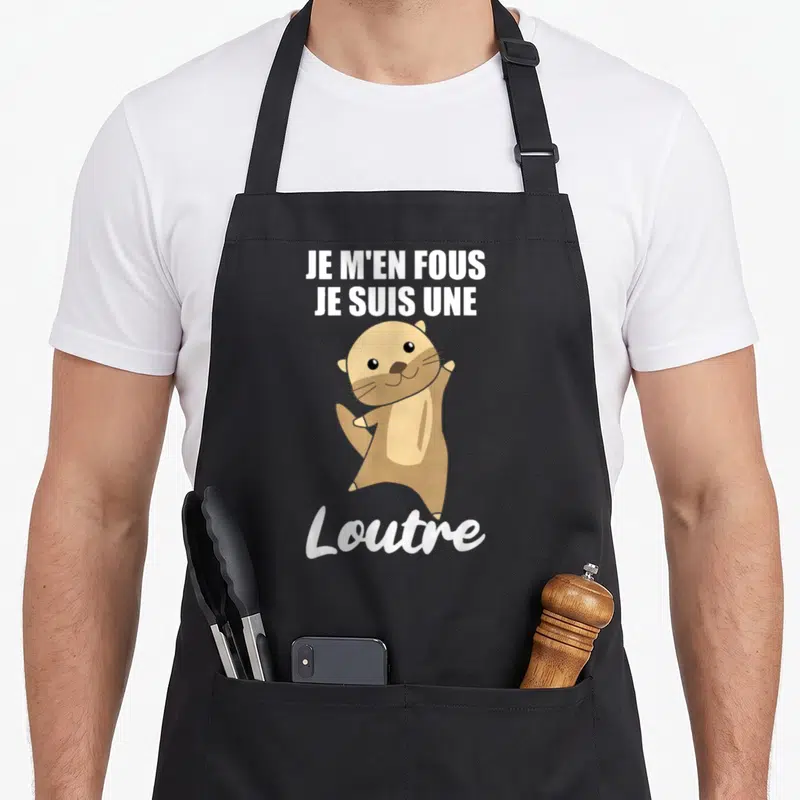 Tablier de cuisine noir avec une loutre marron souriante et le texte Je m'en fous je suis une loutre en blanc.