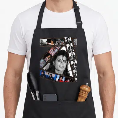 Tablier de cuisine noir avec un grand portrait en noir et blanc entouré de bandes pellicule colorées et monochromes.