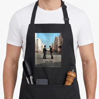 Tablier de cuisine noir avec une illustration de deux hommes en costume se serrant la main, l'un étant en feu.